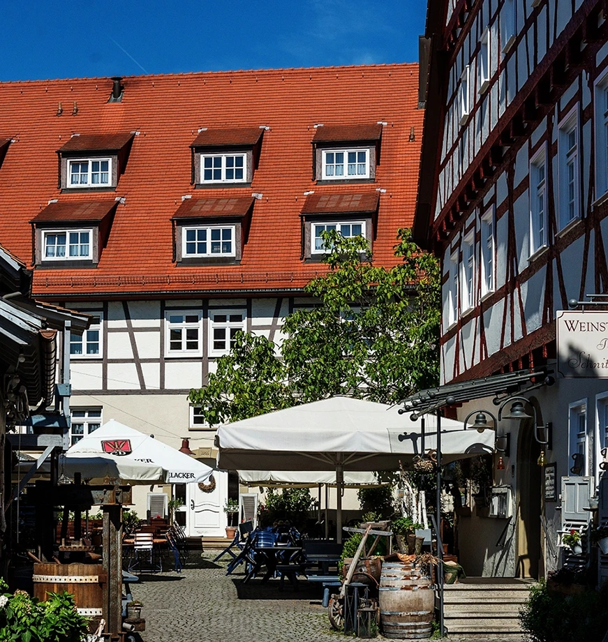 Frick_Holzbau_Restaurierung_historische_Gebaeude_Fellbach Restauriertes Fachwerkhaus in Fellbach mit traditioneller Holzbauweise und gemütlichem Innenhof – Beispiel für denkmalgerechte Sanierung durch Frick Holzbau.